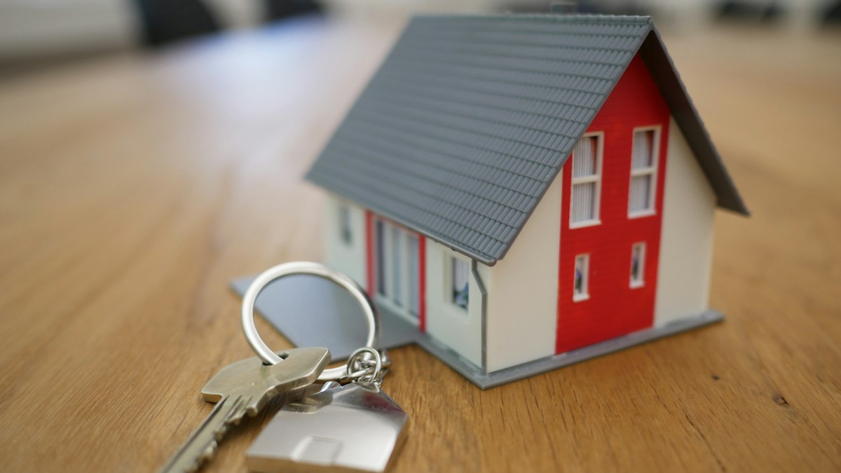 Mortgage loan documentation, house keys, and property paperwork on a desk